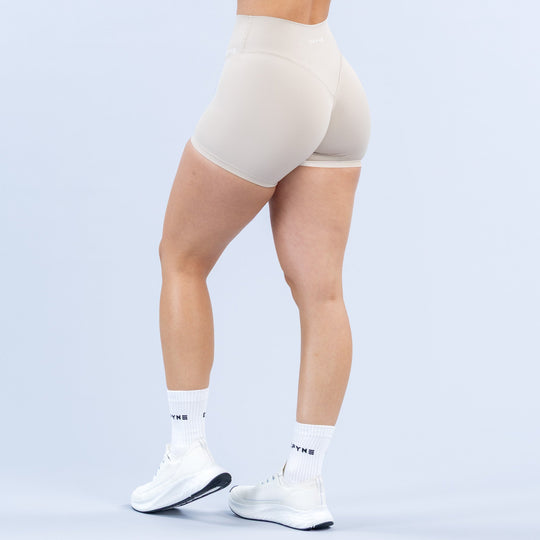 Light off-white 4.5in biker shorts from behind, curved seam lines at hips.