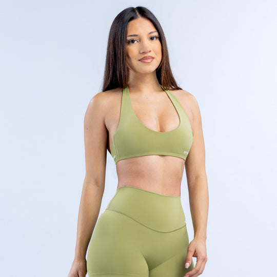 Green halter sports bra with open-back design and wide underband