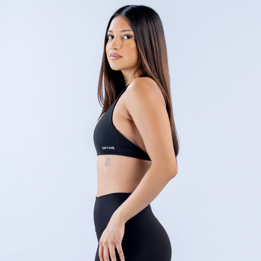 Black halter bralette with minimal coverage and slim racer-back straps