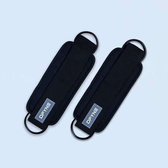 Black fabric ankle straps with curved buckle loops and printed logo patch