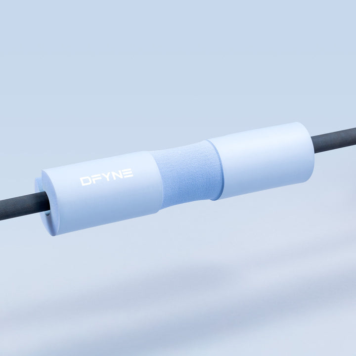 Barbell pad on barbell, light blue foam sleeve with DYNE logo.