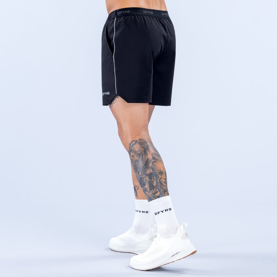 6-inch black training shorts, side view, elastic waistband and contrast piping