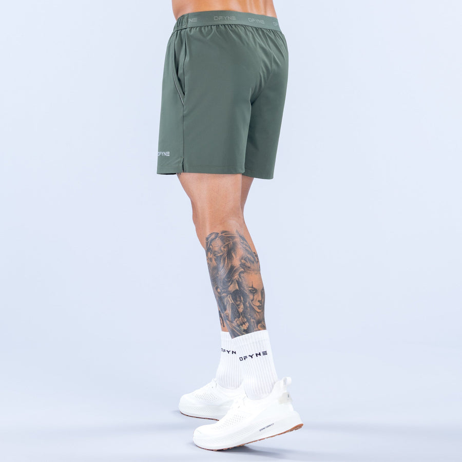 Dark green 6-inch training shorts, side view with elastic waistband and clean hem.