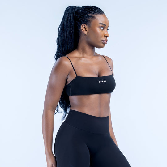 Black strappy bralette with thin spaghetti straps and DYNE logo on front