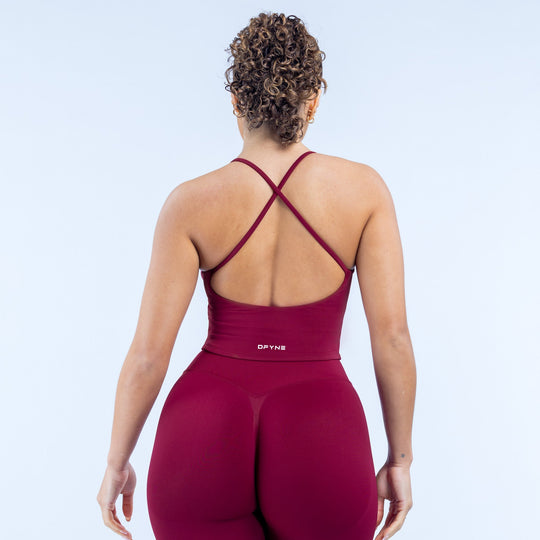 Burgundy strappy sports top with crisscross back straps and fitted scoop neckline