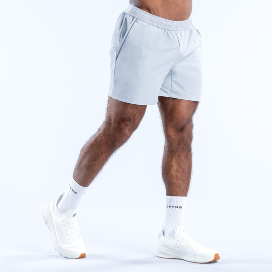 Light blue training shorts, side view, elastic waistband and logo at hem