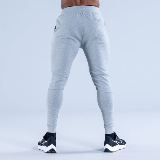 Light gray tapered jogger pants, rear view, with drawstring and cuffed hem