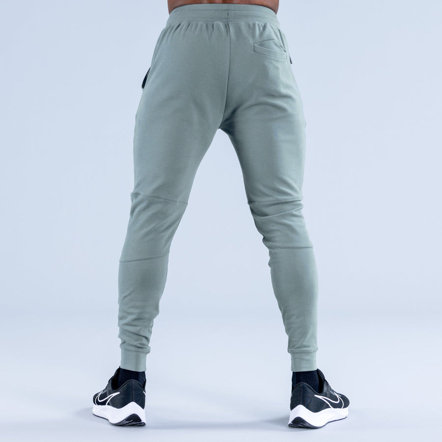 Sage green tapered jogger pants from behind with drawstring waist and back yoke