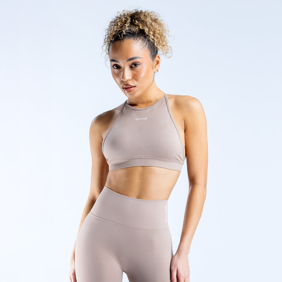 Taupe high neck backless sports bra with racer-style front and strappy back