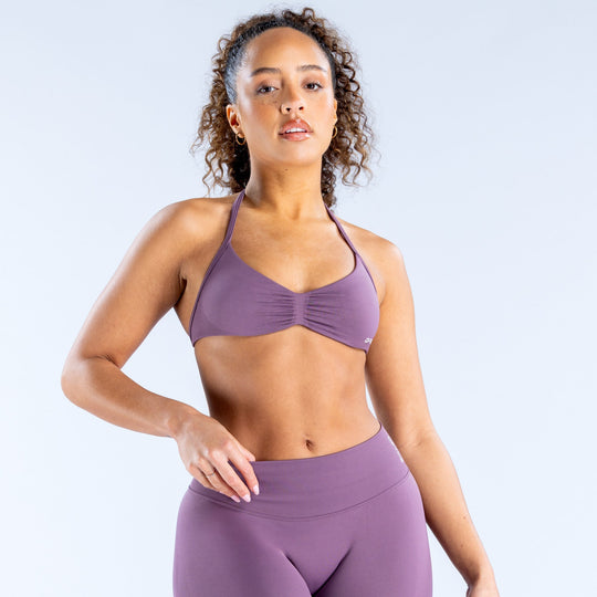 Purple strappy sports bra with ruched center and thin adjustable straps