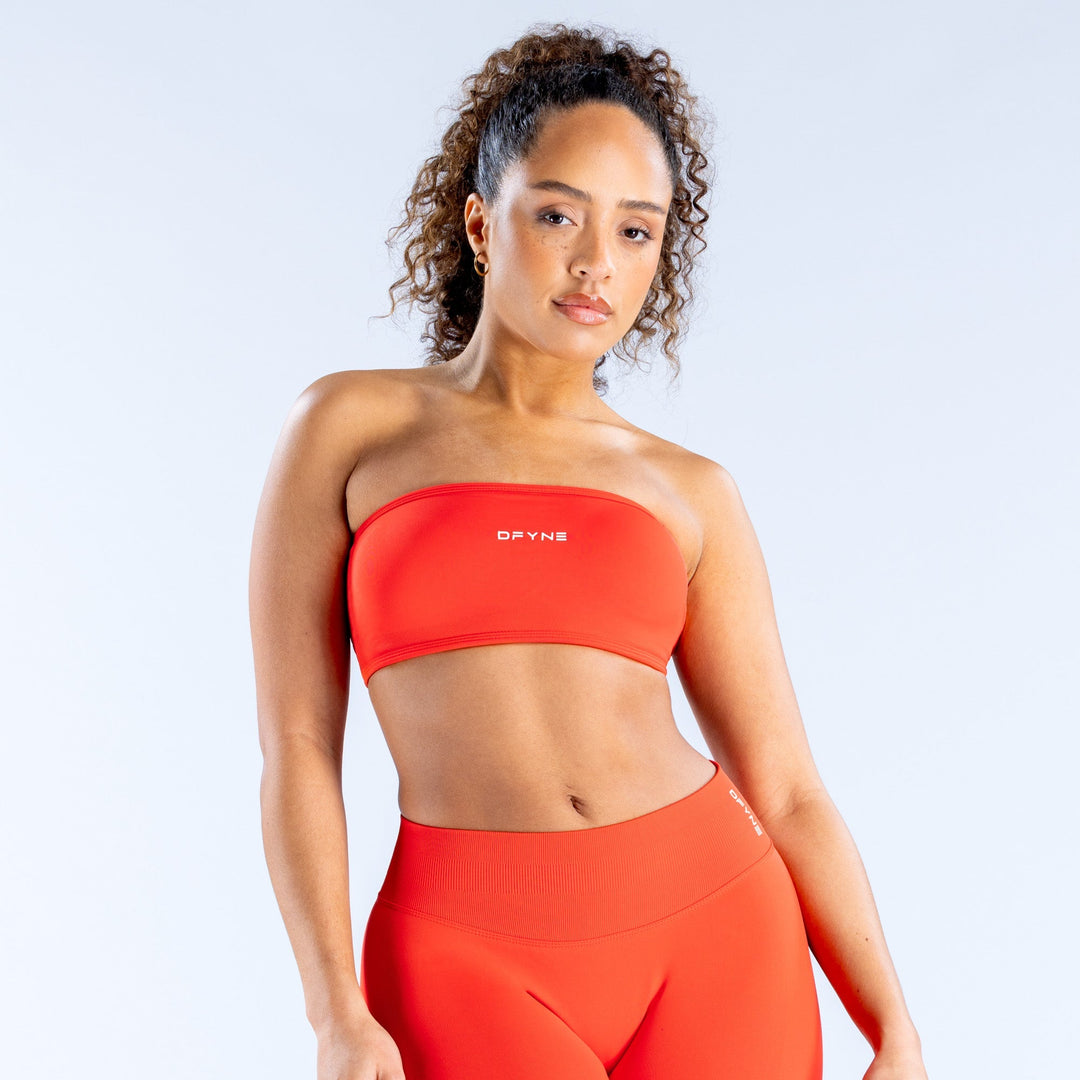 Red backless bandeau sports bra with wide elastic band and small front logo.
