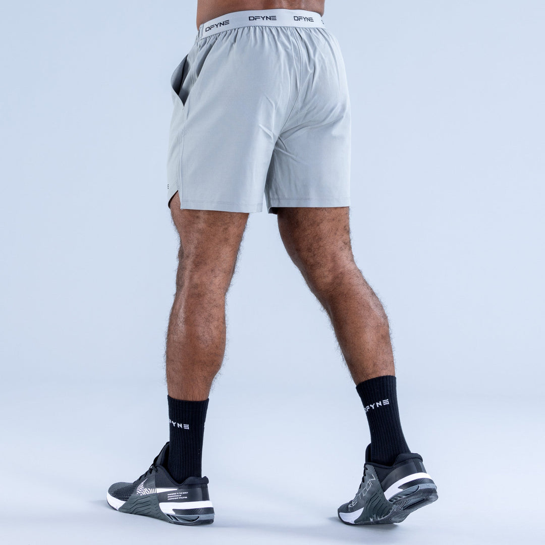 Men's light blue training shorts, back view, elastic waistband and DPYNE logo