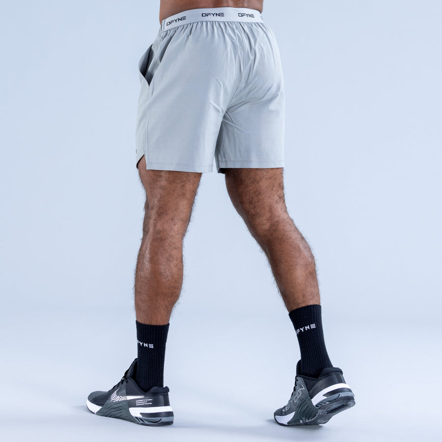 Men's light blue training shorts, back view, elastic waistband and DPYNE logo