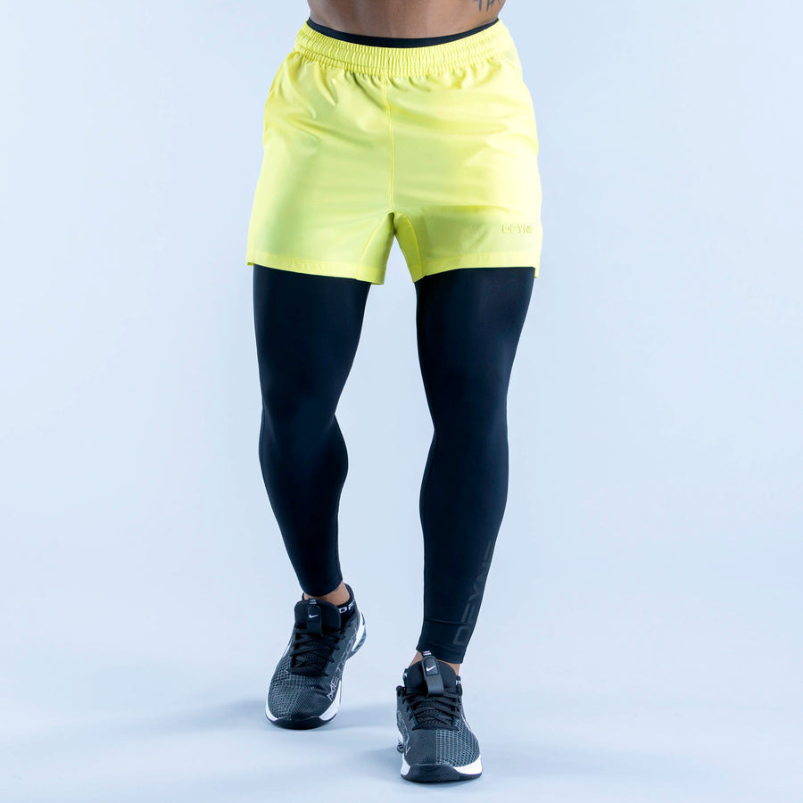 Two-tone compression base layer bottoms with neon yellow waistband and black fitted legs