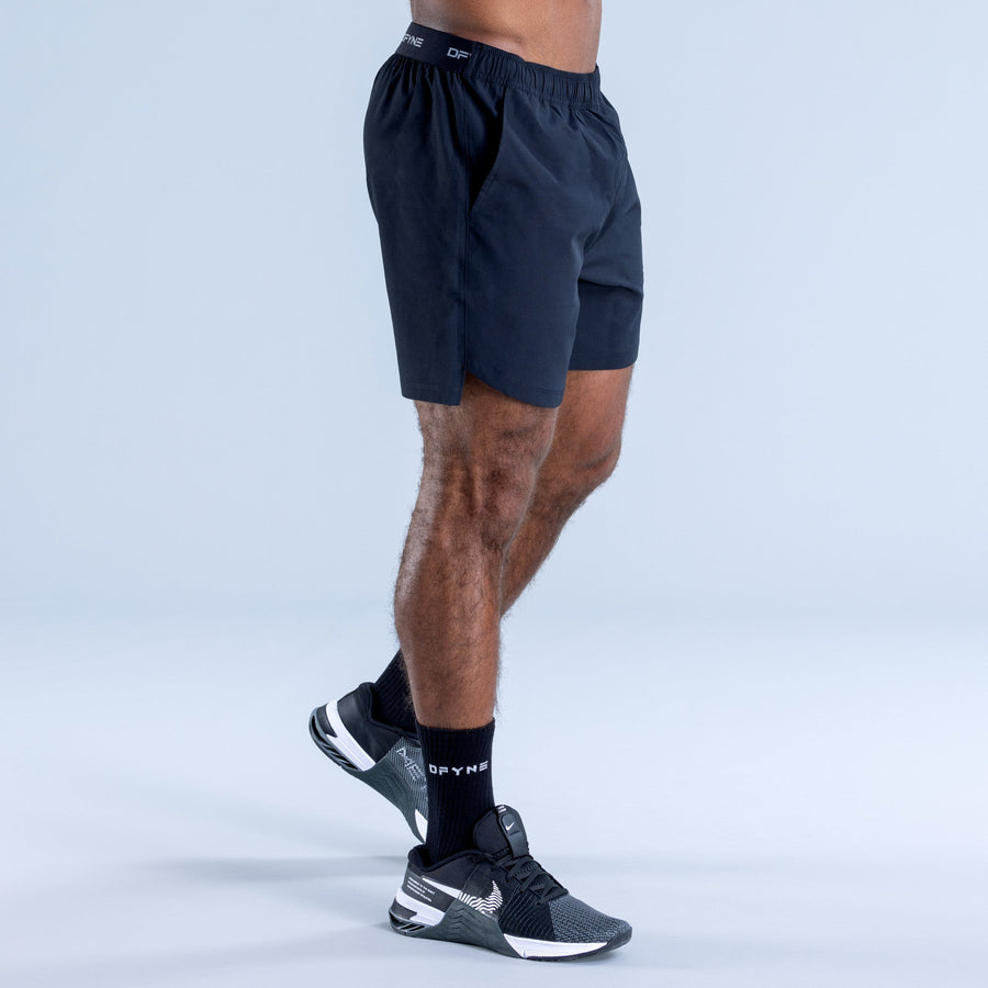 Dark navy training shorts with elastic waistband and knee-length hem