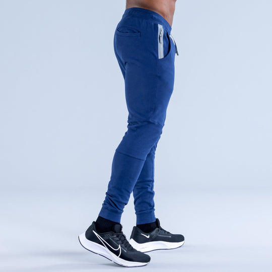 Blue tapered jogger pants with side pocket detail and elastic ankle cuffs