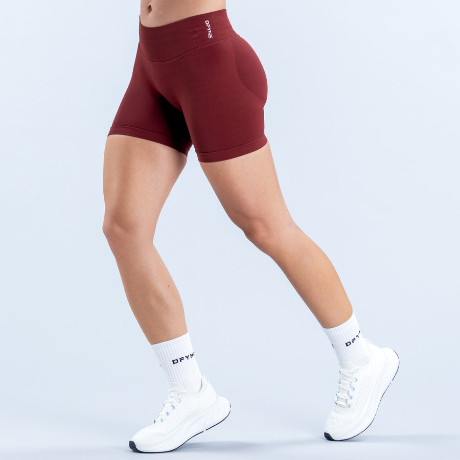 Burgundy 4.5-inch athletic shorts with a high waist, shown from the side
