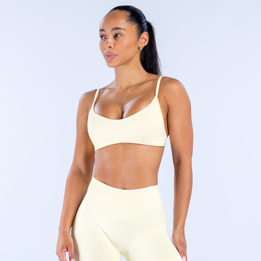 Cream scoop-neck bra with thin straps and smooth, supportive cups
