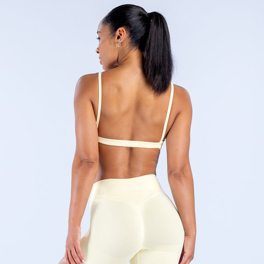 Cream scoop-neck sports bra with thin straps, racerback style