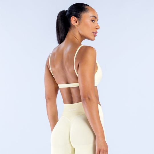 Cream scoop-neck bra with adjustable straps and racerback panel