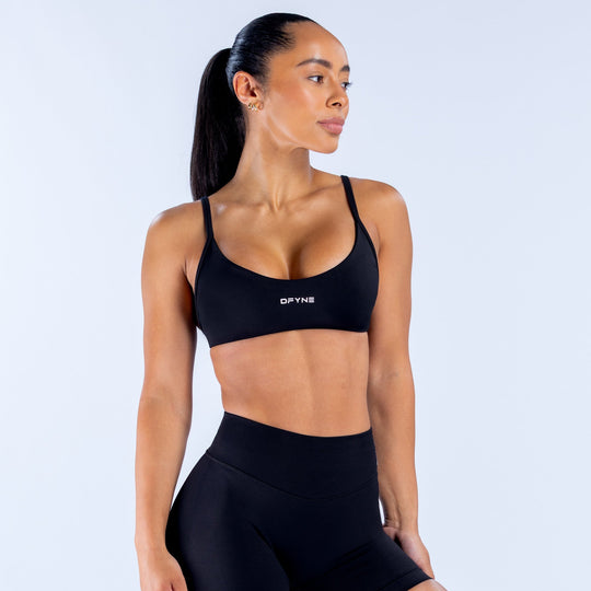 Black scoop-neck sports bra with DPYNE logo and supportive underband
