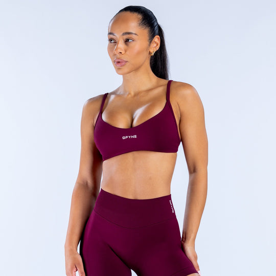 Burgundy scoop-neck sports bra with thin straps, front view