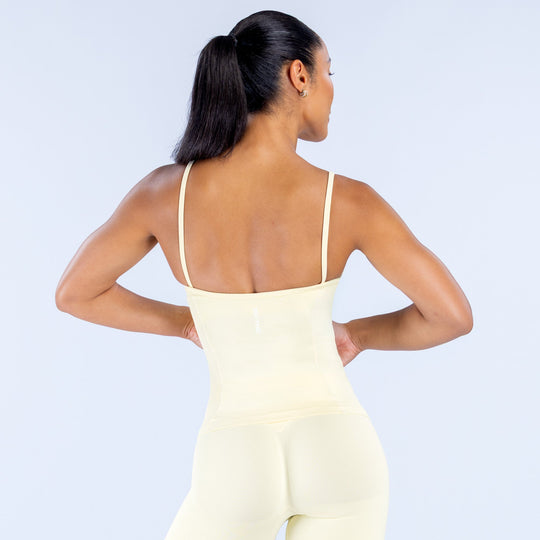 Cream scoop-neck sleeveless top with open back and thin straps, fitted