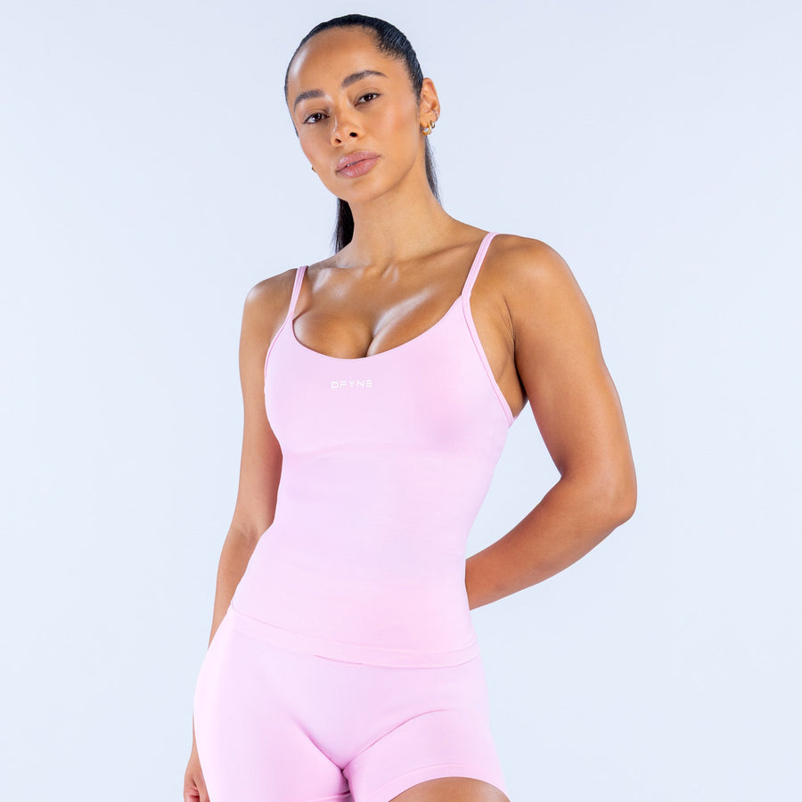 Light pink scoop-neck athletic tank top with thin straps, front close-up