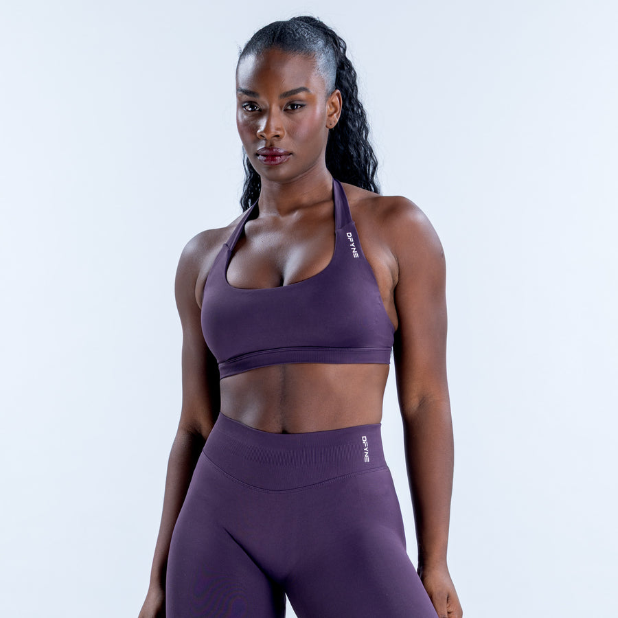 Purple impact sports bra with a scoop neckline and halter straps, shown from the front.