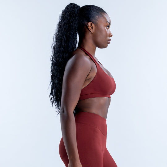 Side view of the burgundy Impact Sports Bra with a scoop neckline and halter strap