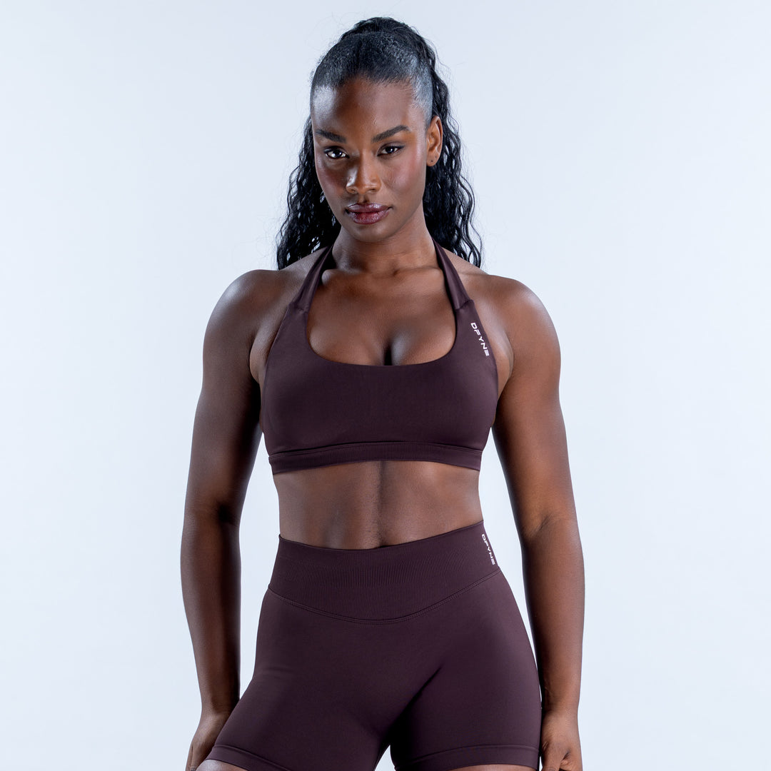 Dark plum Impact Sports Bra with a scoop neckline and halter straps, shown from the front.