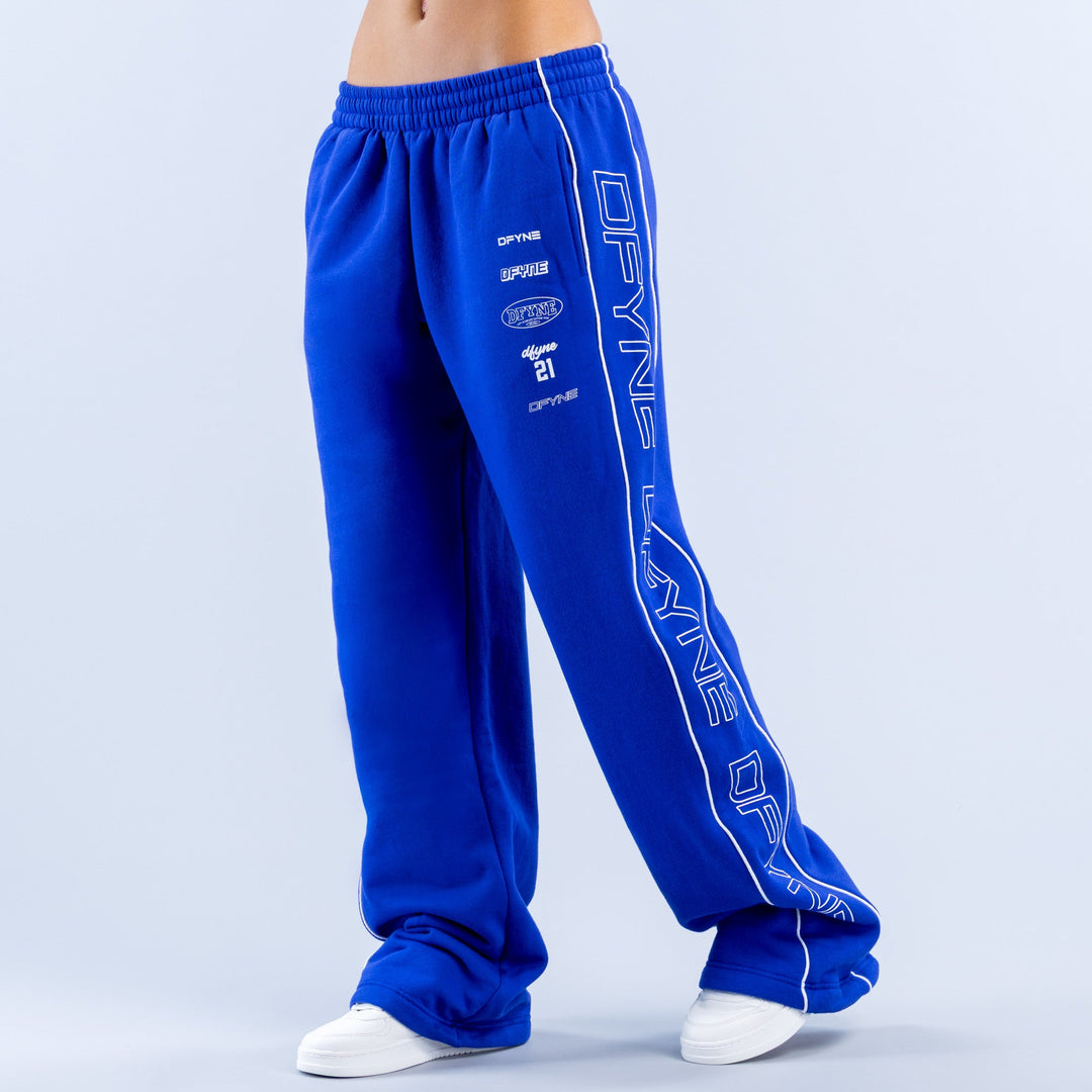 Blue wide-leg jogger pants showing side graphic and relaxed taper to ankle cuffs