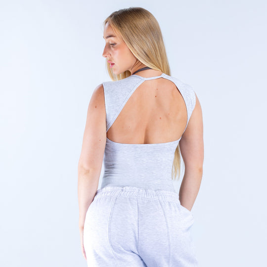 Back view: heather gray ribbed crop top with open back and thin crisscross straps.