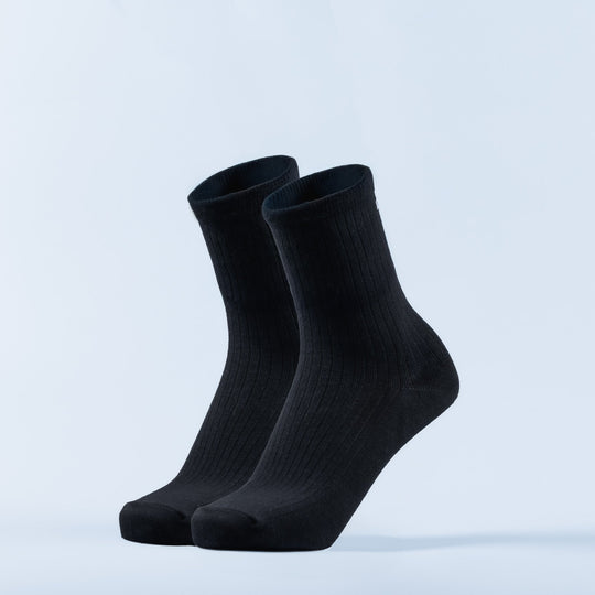 Pair of black crew socks with ribbed knit and smooth cuffs.