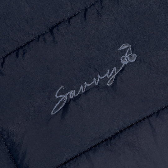 Embroidered script logo on dark quilted puffer bag panel