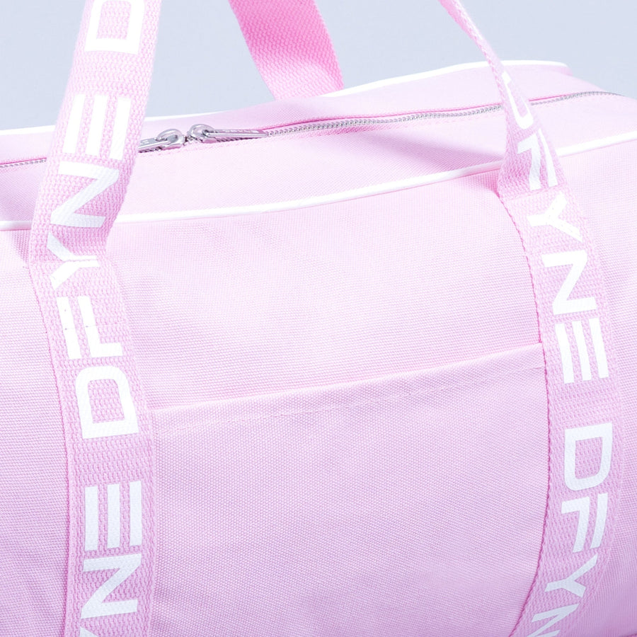 Light pink duffle bag close-up: zip pocket front and webbing shoulder straps.