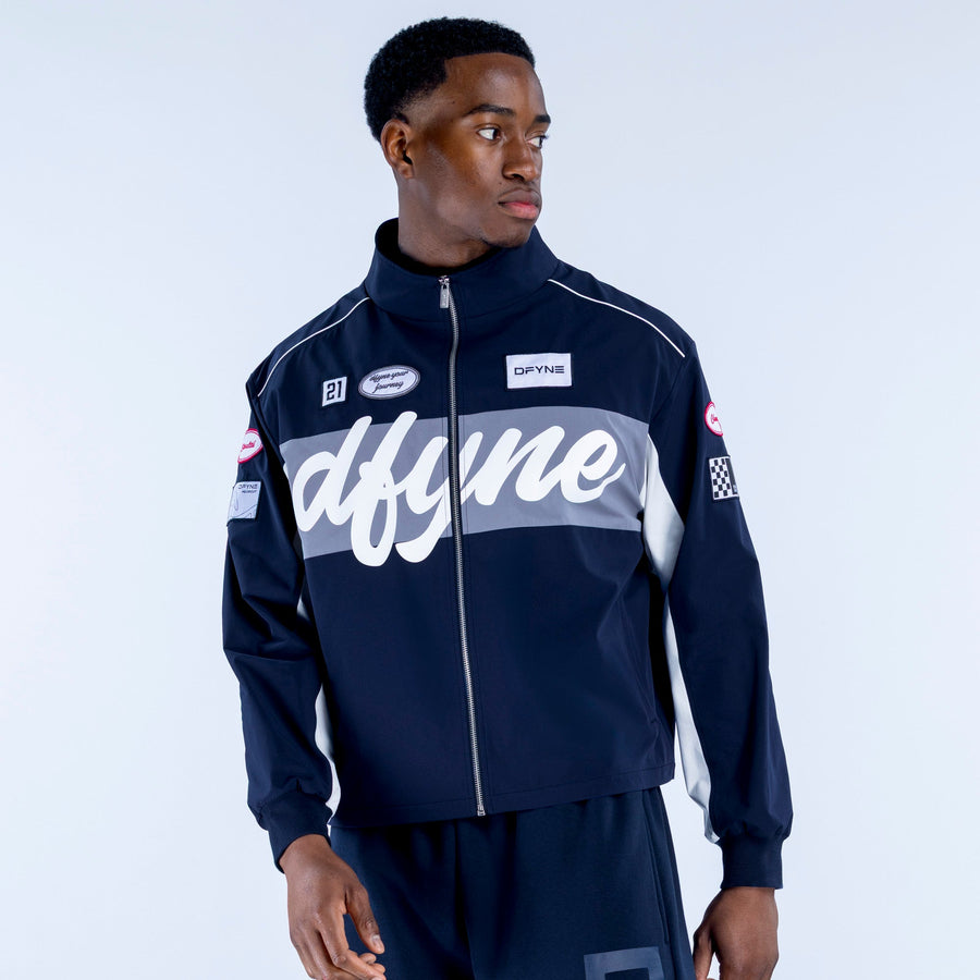 Men's navy track jacket with white script graphic panel, stand collar, zip