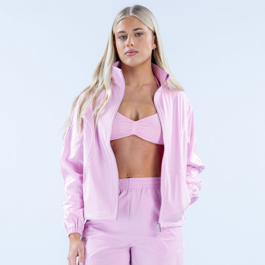 Pink track jacket worn open with full-zip and elastic waistband