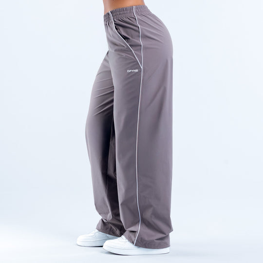 Dark gray track pants with white side stripe, elastic hem, rear view with logo