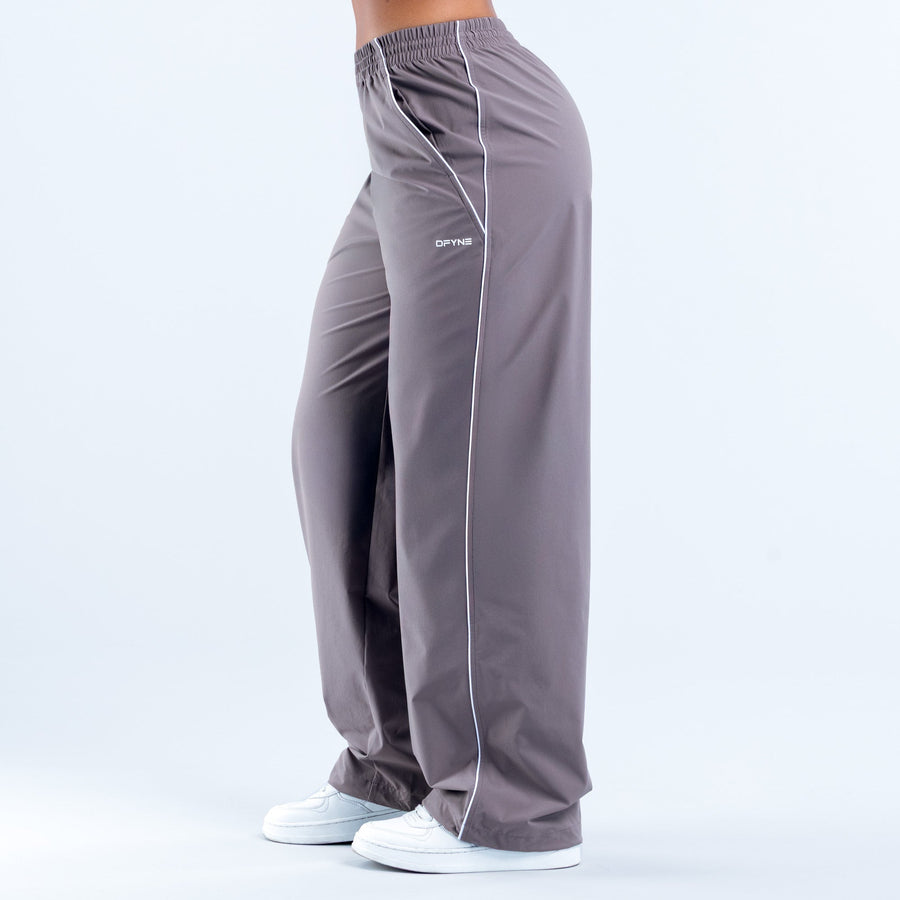 Dark gray track pants with white side stripe, elastic hem, rear view with logo