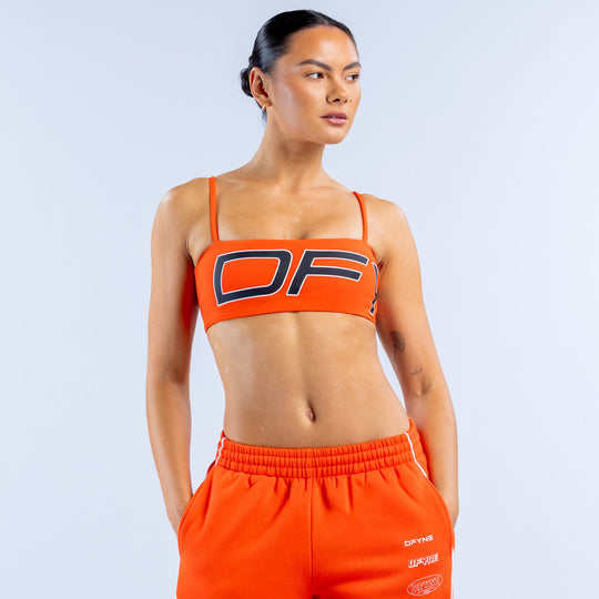 Orange sports bra with bold OF logo and contrast striped trim on wide straps