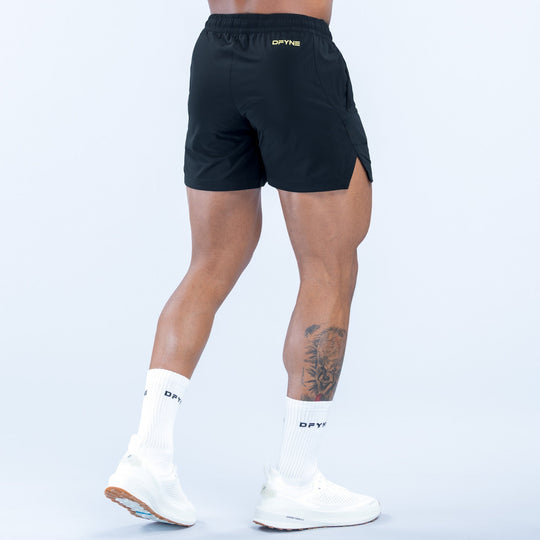 Men's black training shorts, back view with elastic waistband and logo trim