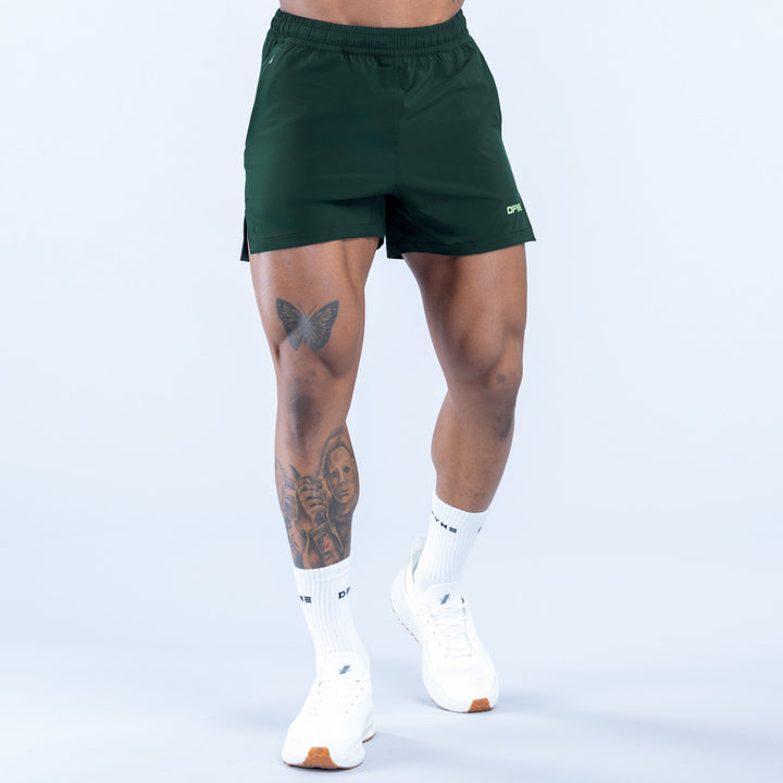 Green training shorts with elastic waistband and small logo on leg