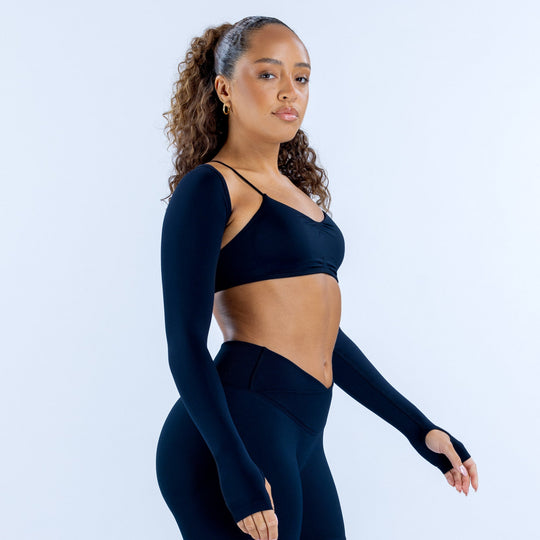 Navy long-sleeve shrug with thumbholes, worn over a sports bra