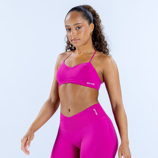 Fuchsia sports bra with thin straps and DYNE logo at center front