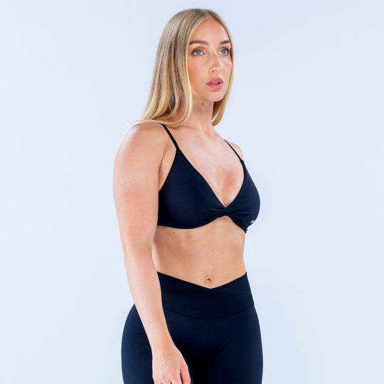 Twist-front sports bra in dark navy with V-neckline and DYPYN logo